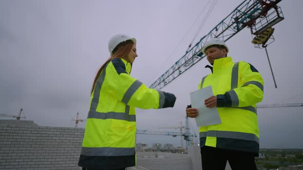 Female Building Inspector and Male Civil Engineer are Shaking Hands in Construction Site