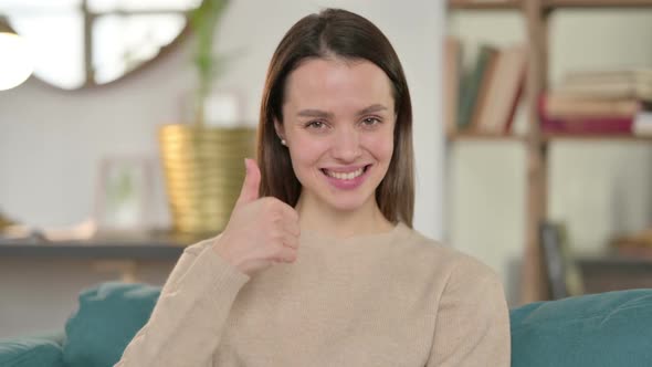 Portrait of Young Woman with Thumbs Up at Home