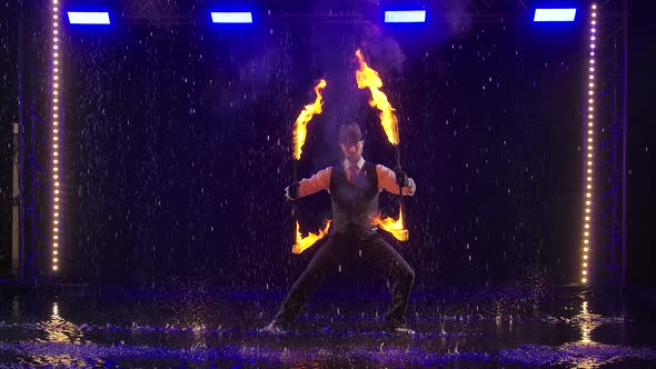 Fire Show in the Rain in the Studio. Professional Artist Performs a Variety of Fire Facilities in