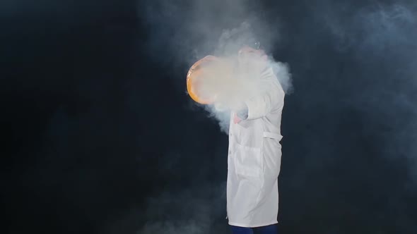 Man Chemist in Uniform and Protective Glasses Making Interesting Trick with Air Smoke Bubble, Rounds