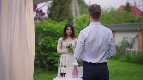 Back View of Loving Groom Waiting for Gorgeous Middle Eastern Bride Walking to Wedding Altar