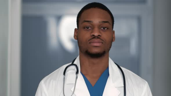 Close Up of Confident African American Doctor Looking Seriously at Camera Posing at Clinic Interior