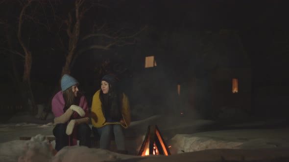 Girls spend time together near fire.