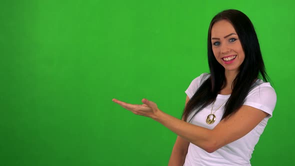 Young Pretty Woman Introduces Something - Green Screen - Studio