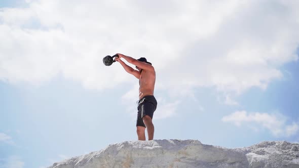 Man doing kettlebell workout. Athlete training and doing workout outdoors