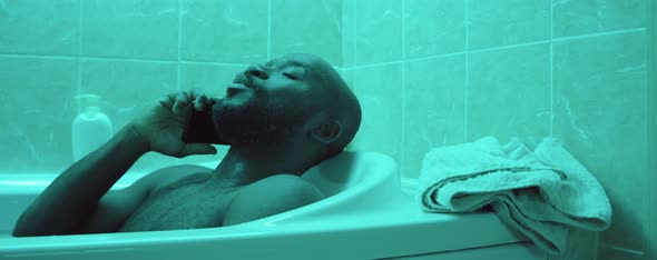 African American Man Talking on Phone in Bath