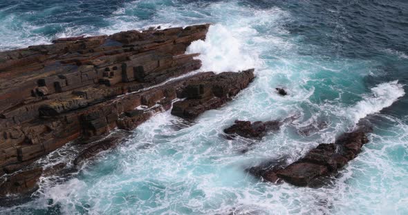 Low swells roll in and break around the rocks in a foaming torrent at Admirals Arch on Kangaroo Isla