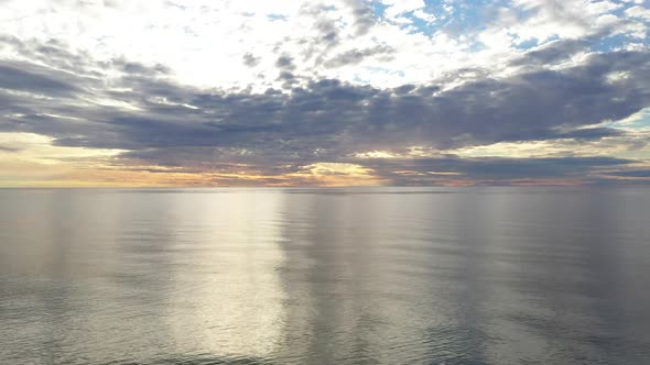 AERIAL: Pan Shot of Flying Above Baltic Sea During Golden Hour with Majestic Horizon