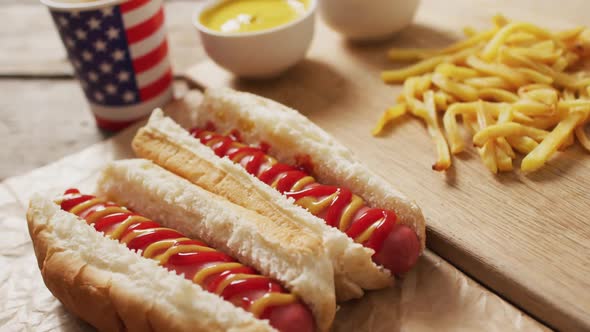 Video of hot dogs with mustard, ketchup and chips on a wooden surface