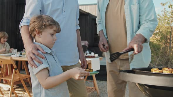 Boy Getting Hot Grilled Corn