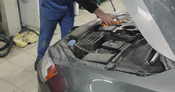 Car Service. Mechanic Top Up The Engine Oil