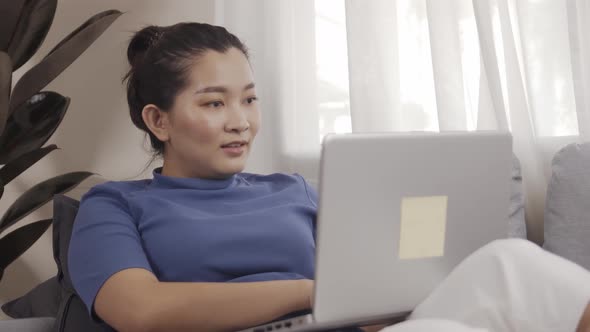 Asian business woman happily use laptops to work from home online