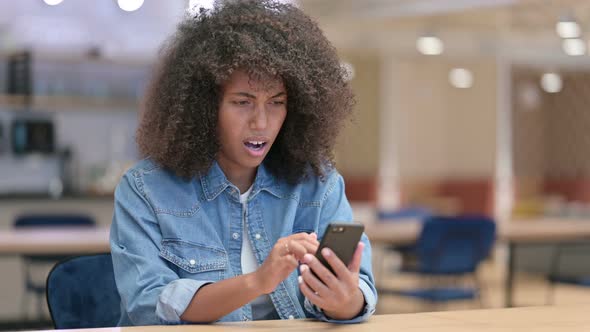 Disappointed Young African Woman Having Loss on Smartphone 