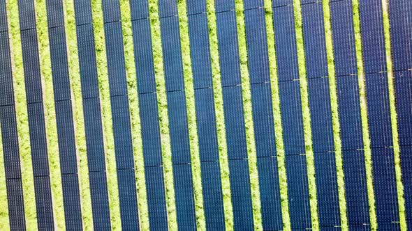 Drone producing eye capturing visual effect by rotating high above rows of solar panels.