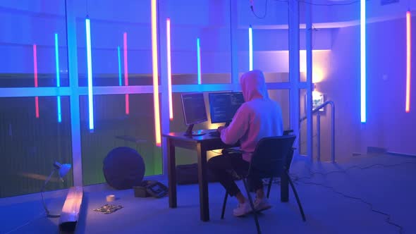 Hacker Working Place: Hacker Working in a Room with Colored Neon Lights