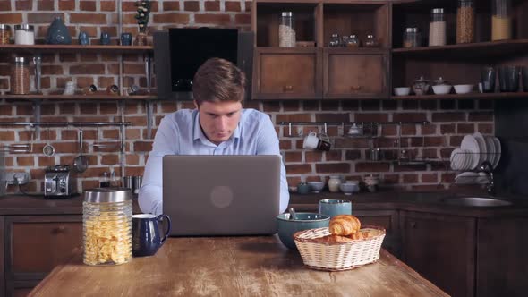Young Guy Reading News on Computer in the Morning
