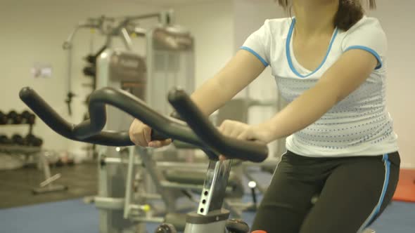 MS TU Young girl using stationary bike in gymnasium