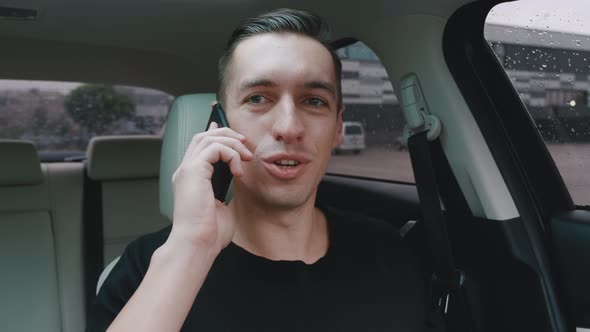 Portrait Smiling Young Man Talking Phone at Car. Happy Man Driver Communicates Using Smartphone