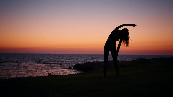 Young Woman with Slender Body Practising in Fitness Exercises During Evening