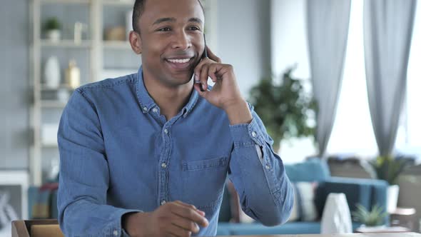 Young African Man Discussing Work on Phone