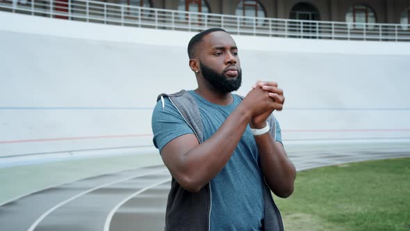 Sportsman Warming Hands Before Training at Stadium. Guy Training Outdoors