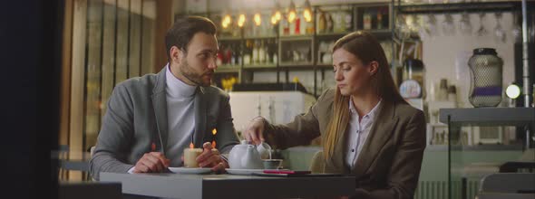 Man and woman sitting in evening in cafe