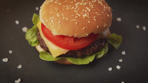 Delicious Cheeseburger on a Black Table with Salt Crystals