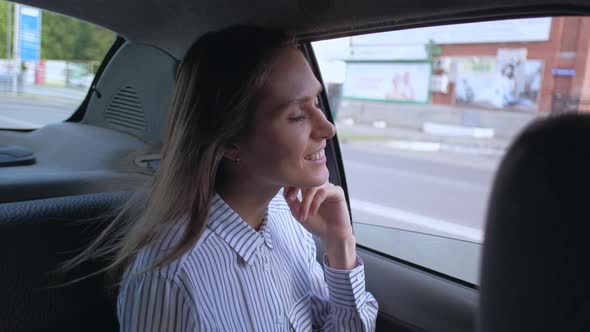 Brunette Girl Rides in Taxi in Backseat Enjoying the Ride