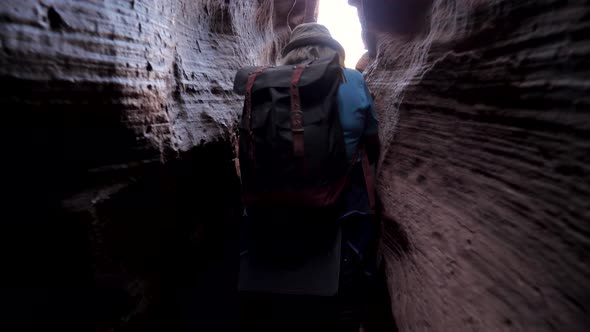 Hiker Tourist Hardly Walking In The Narrow Canyon Of The Cave Outside