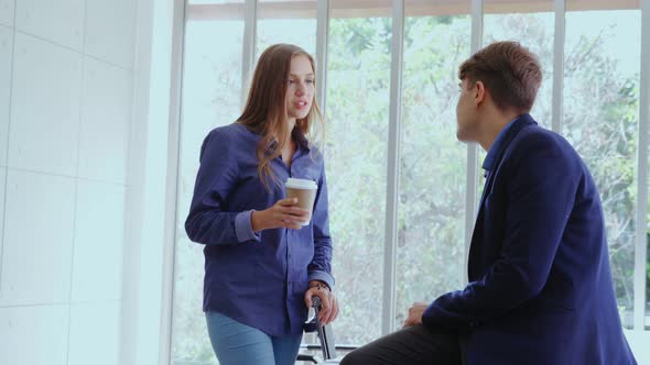 Happy Businesswoman and Businessman Having Conversation in Modern Office