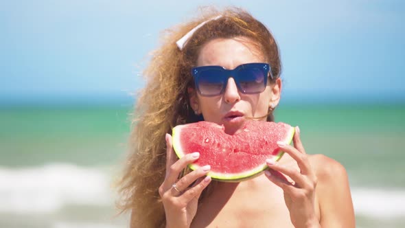 Smiling Woman Eating Watermelon on Beach