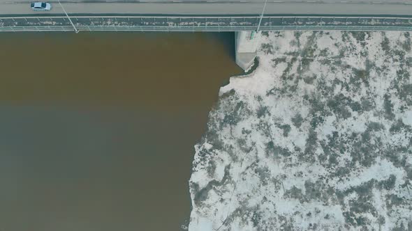 Brown Dirty River Water Covered with Melting Ice Surface