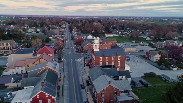 A Drone Approaching View of a Small Town and a Steeple at Sunrise as it gets Ready to Break the Hori