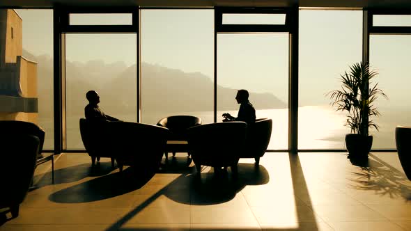 Two Business Partners Having a Meeting In Modern Office Lobby Hall Talking Together