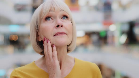 Female Portrait Mature Caucasian Woman Tourist Keeps Hand on Chin Carefully Examines Surroundings