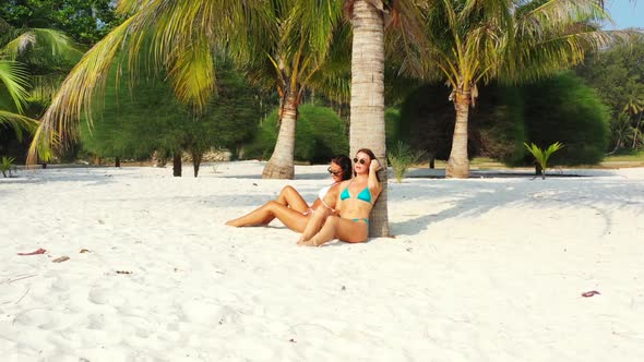 Women tanning on beautiful bay beach vacation by blue lagoon and clean sandy background of Thailand 