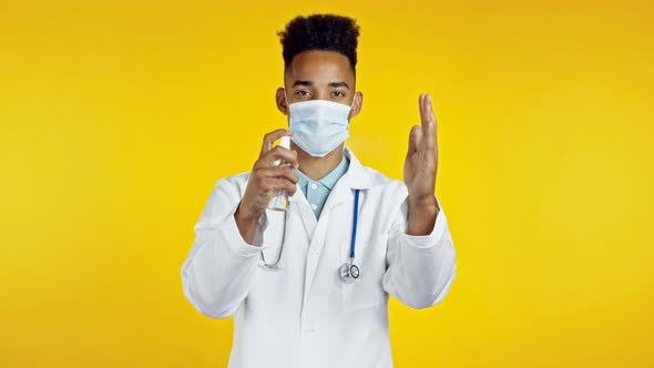 African Doctor in Protective Mask Applies Disinfectant Antiseptic To His Hands and Then Shows - It