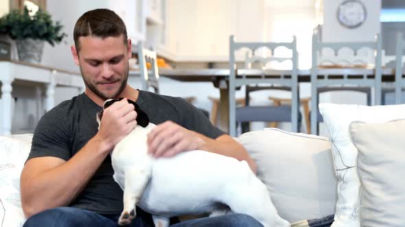 Happy man playing with pug dog 