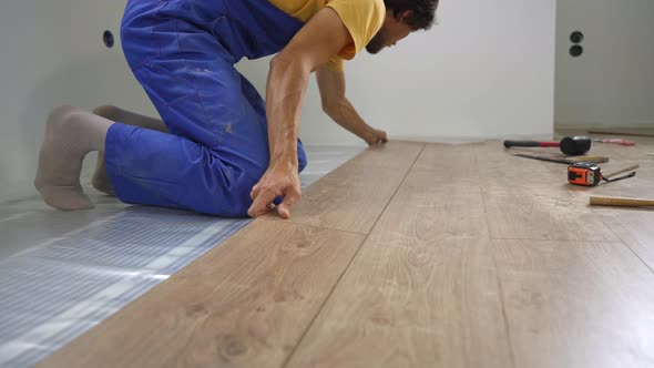 A Man Professional Laminate Installer Laying Laminate Wood