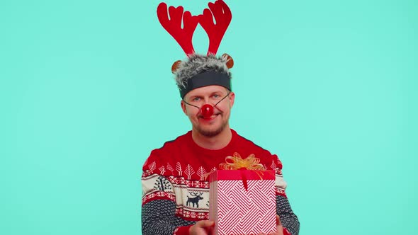 Funny Man Wears Red New Year Sweater and Deer Antlers Presenting Christmas Gift Box Shopping Sale
