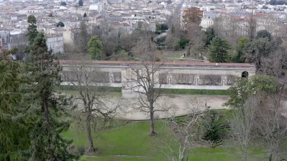 The Botanical garden of Bordeaux, France with long gate building, Aerial dolly in reveal shot