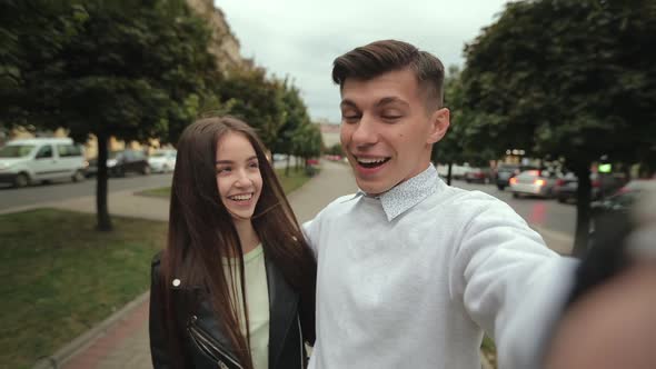 A Man and a Woman are Taking Selfies