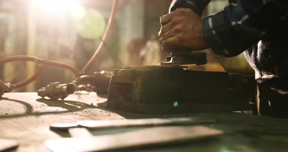 Bladesmith deburring metal with angle grinder