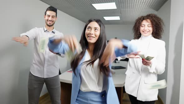 Cheerful Successful Coworkers Scattering Money and Dancing in Office