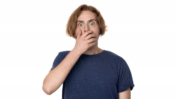 Portrait of Surprised Hairy Man Being Shocked and Covering Open Mouth with Hand Isolated Over White