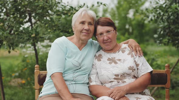 Two Elderly Women Smiling Looking at the Camera.
