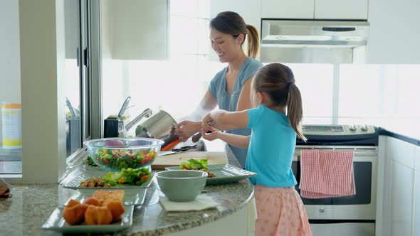 Mother and daughter preparing food in kitchen