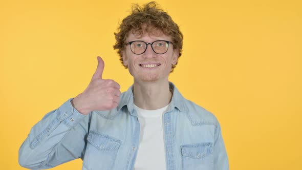 Redhead Young Man with Thumbs Up, Yellow Background 