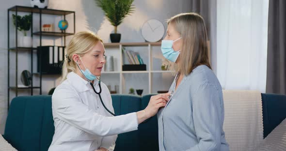 Doctor Checking Heartbeat in Female Patient Using Stethoscope During Home Visit