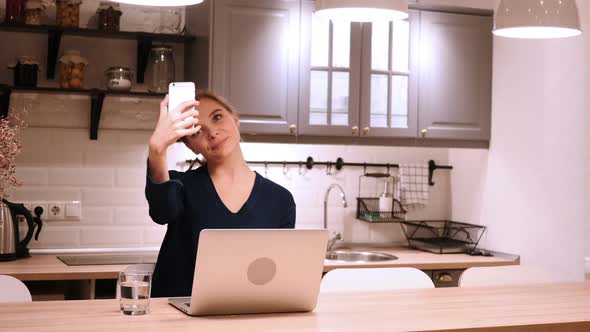 Young Woman Taking Photo with Smartphone Selfie in Kitchen